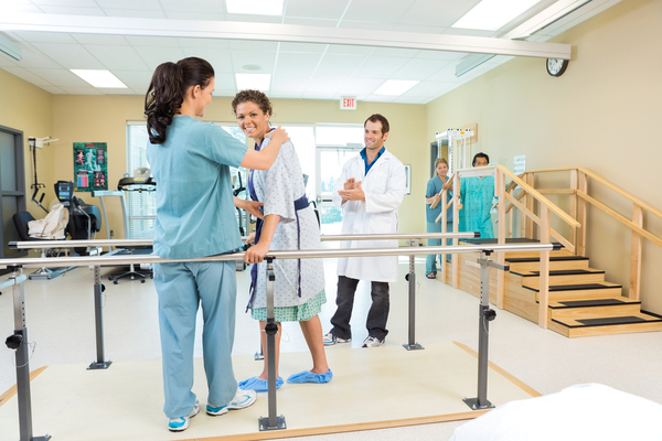 image of a woman working on walking with her physical therapist at the hospital