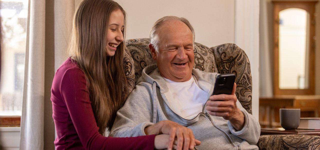 Happy man and child looking at a cell phone