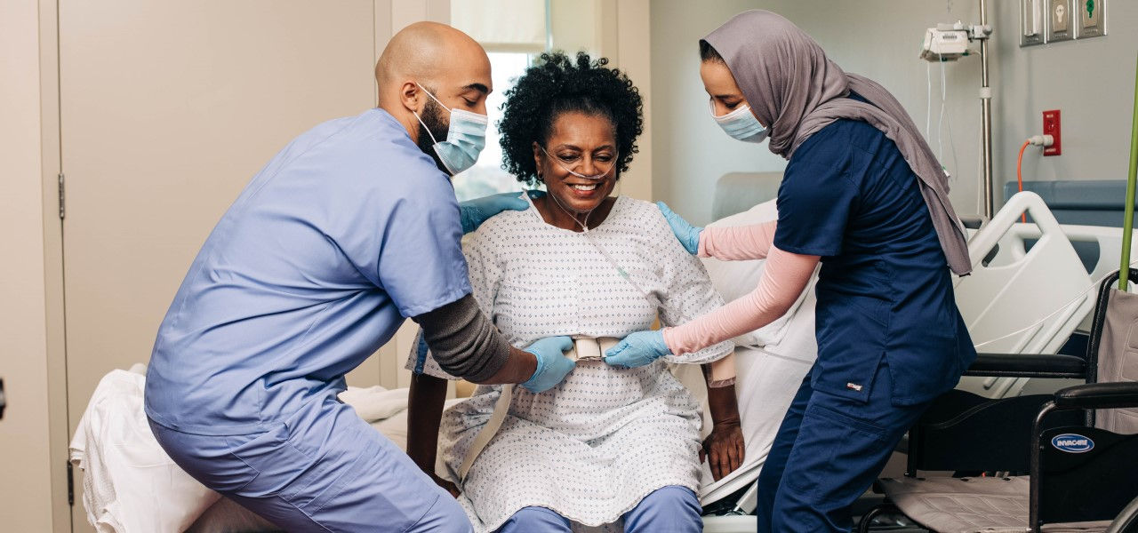 Caregivers helping patient stand