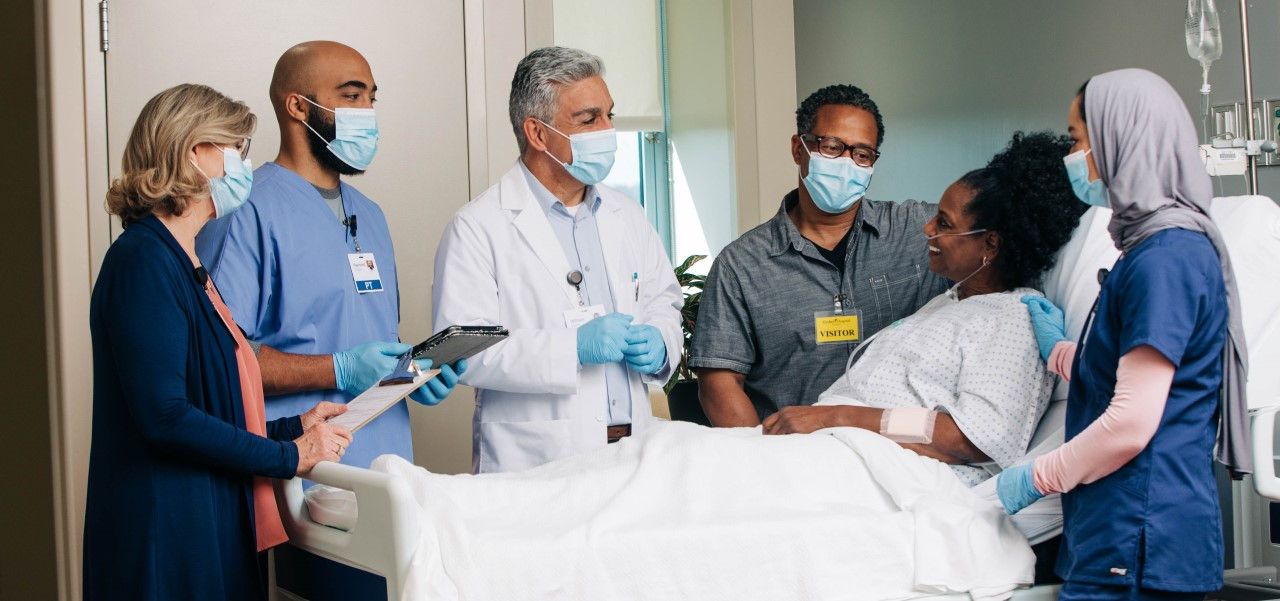 Care team speaking to happy patient