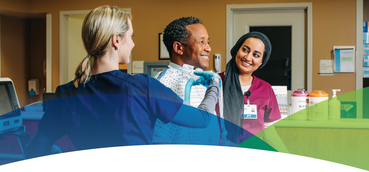 Smiling patient walking with help of caregivers