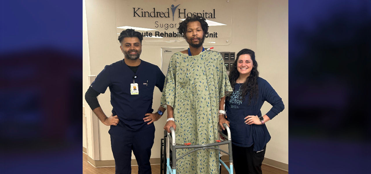 Desmond a patient at Kindred Hospital Sugarland Acute Rehab Unit stands with his support team 