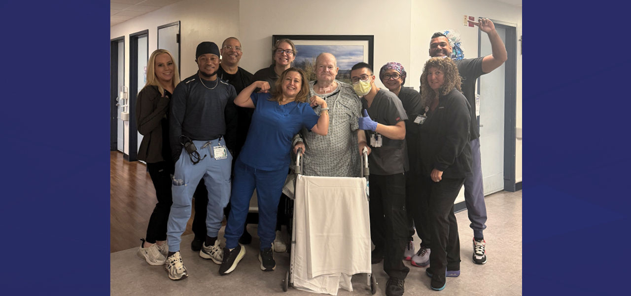 Kindred Hospital East New Jersey patient Earl stands and poses with his care team
