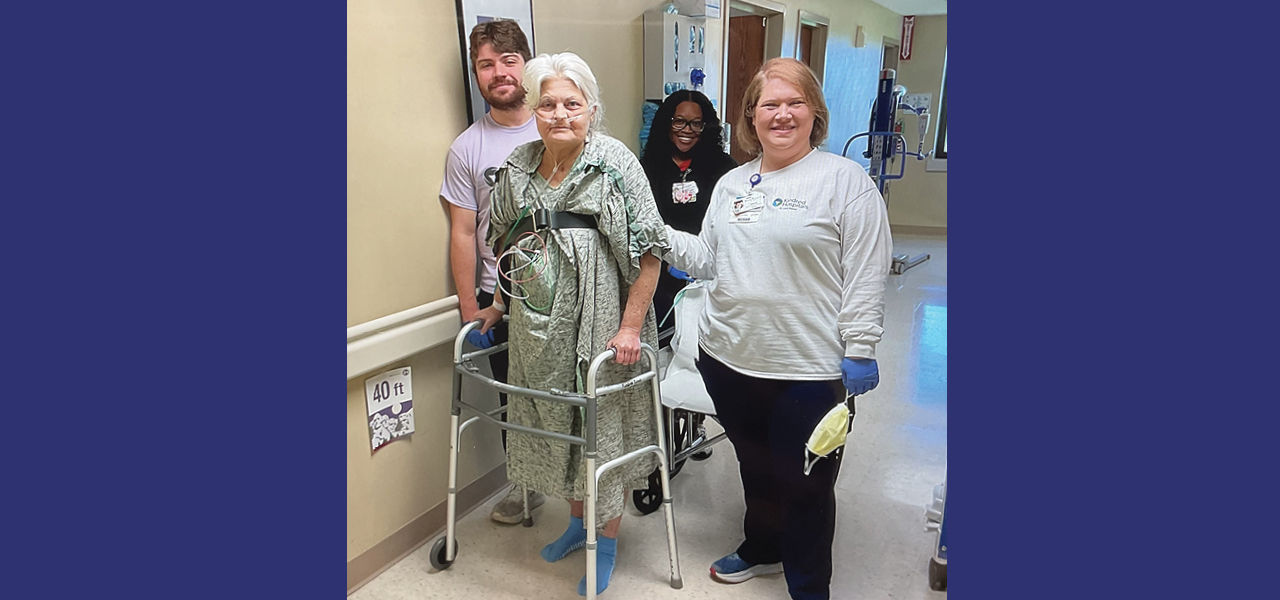 Kindred Hospital St Louis South patient Edna stands and poses with her care team