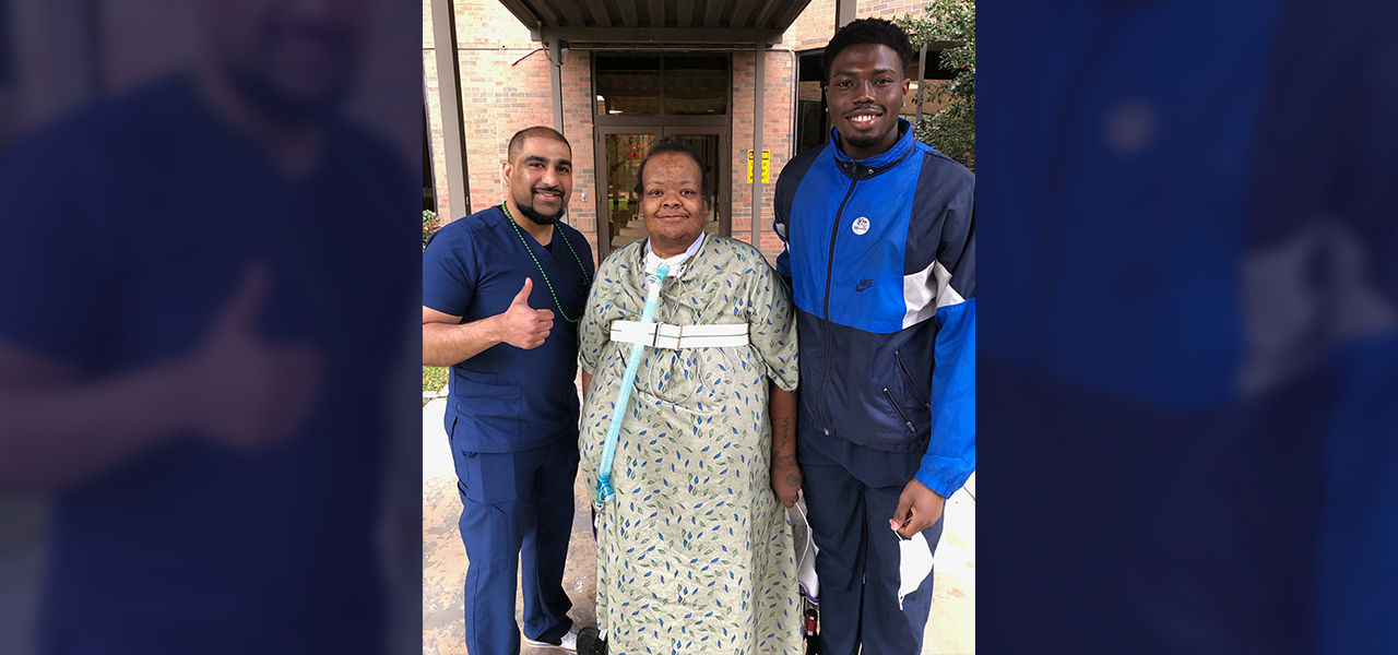 Happy patient leaving hospital with caregivers