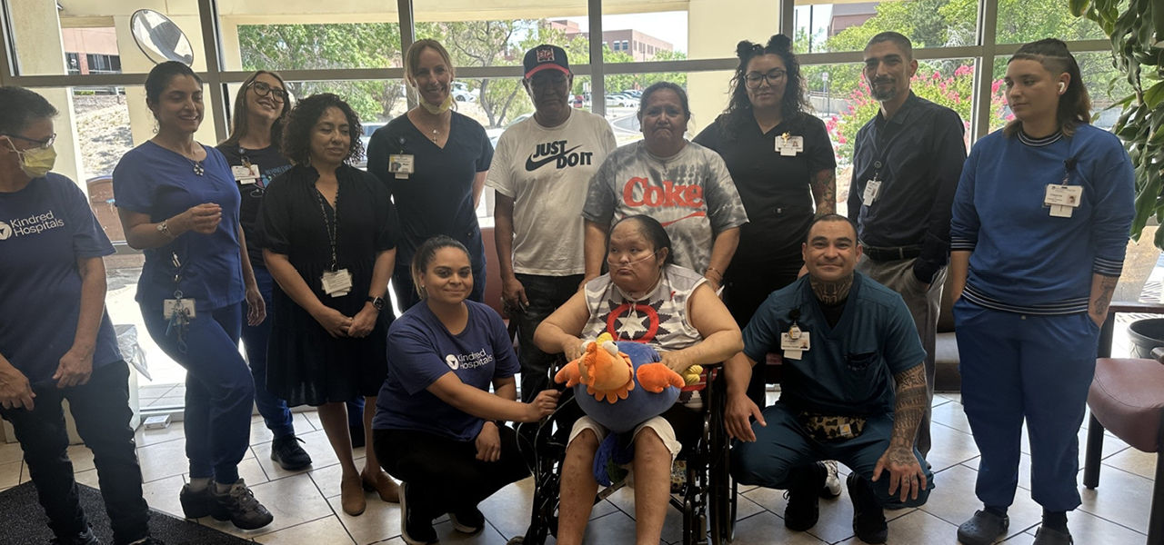 Kindred Hospital Albuquerque patient Gaileen poses with her caregiver team and family