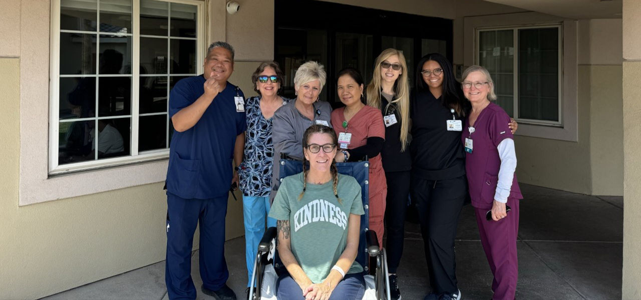 Happy patient in wheelchair with caregivers