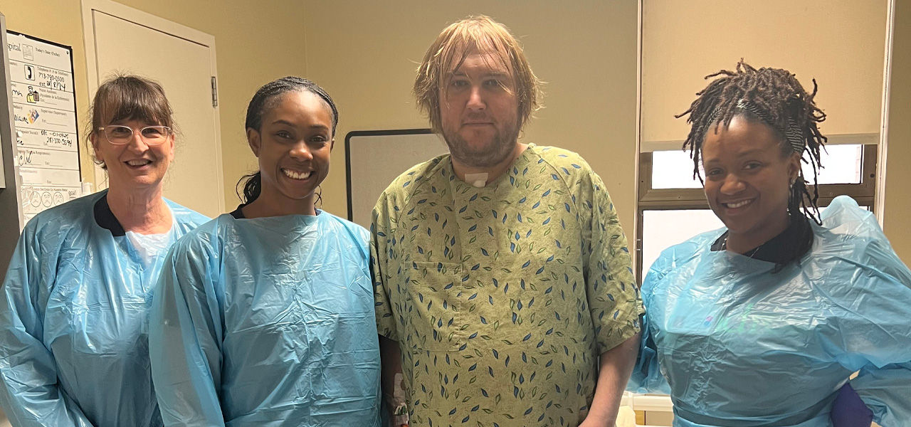 Kindred Hospital Houston Medical Center patient Neil stands with his care team